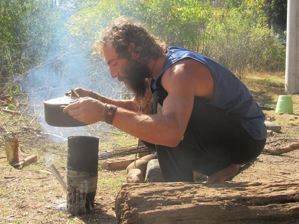 Ben cooking over a fire while living off-grid
